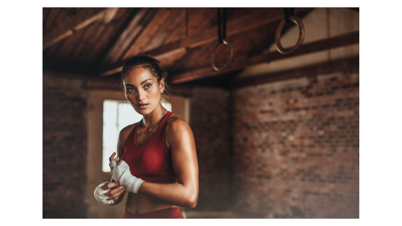 Femme en tenue de sport préparant ses mains avant l'entraînement, symbolisant la préparation et la protection contre les manipulateurs.