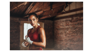 Femme en tenue de sport préparant ses mains avant l'entraînement, symbolisant la préparation et la protection contre les manipulateurs.